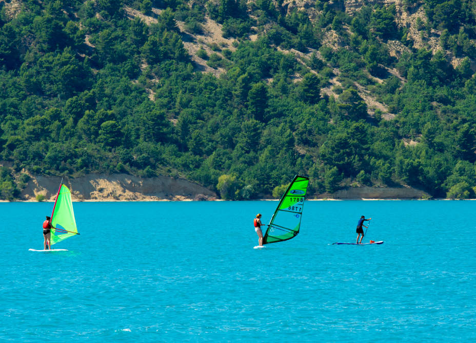 photo du lac de sainte croix avec deux planches à voile et un paddle dessus